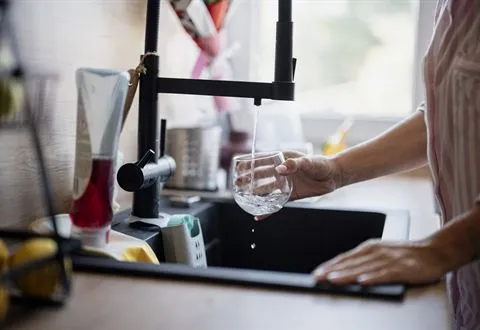 A glass being filled at a kitchen tap